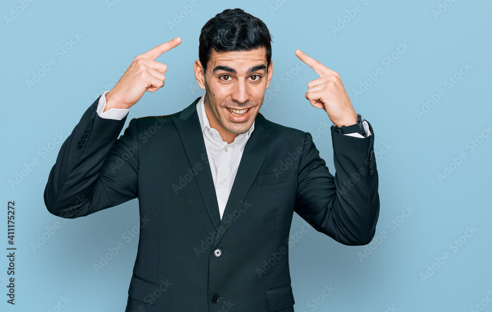 Handsome hispanic man wearing business clothes smiling pointing to head with both hands finger, great idea or thought, good memory Handsome hispanic man wearing business clothes smiling pointing to head with both hands finger, great idea or thought, good memory