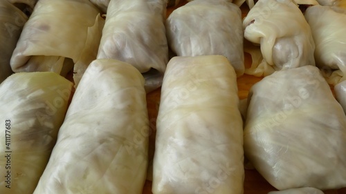 the cook makes cabbage rolls from white cabbage and meat