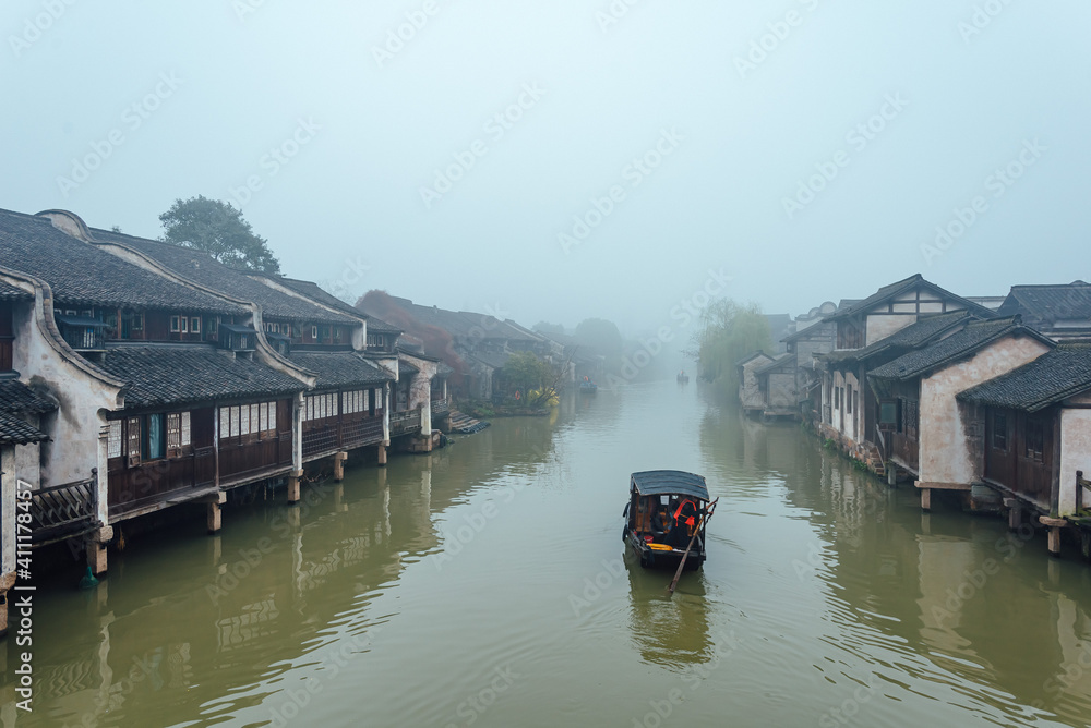 WUZHEN,CHINA-MARCH 6,2012: Ancient buildings along the canal. Morning fog over the city.