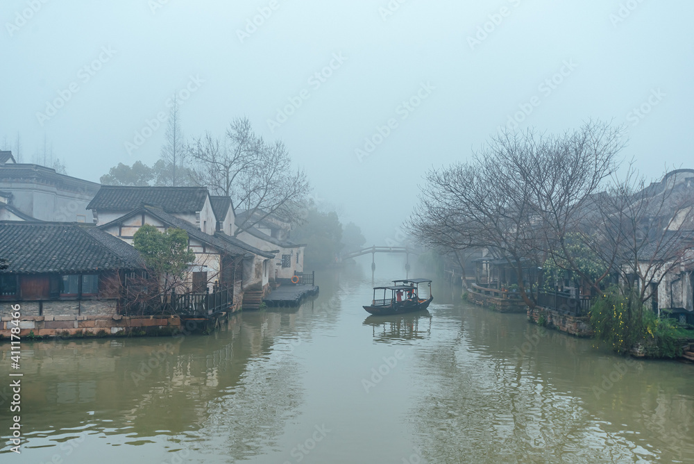 WUDZEN,CHINA-MARCH 6,2012: Ancient buildings along the canal. Morning fog over the city. WUDZEN,CHINA-MARCH 6,2012: Ancient buildings along the canal. Morning fog over the city.
