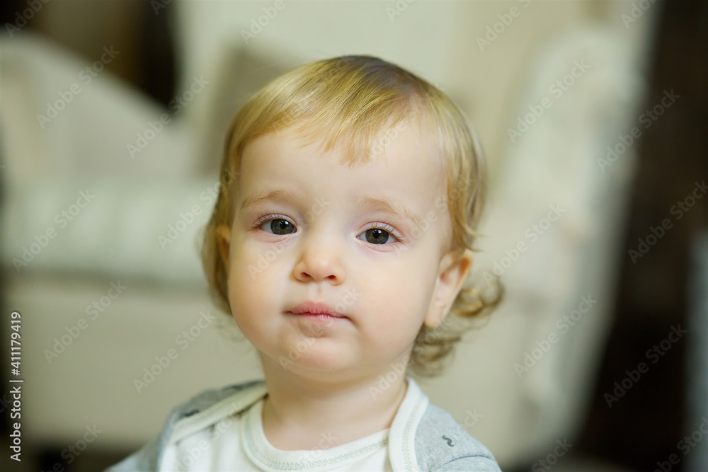 A small infant boy looks at the camera.