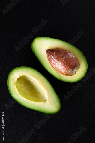 Macro shot of fresh avocados cut in a half on the black background