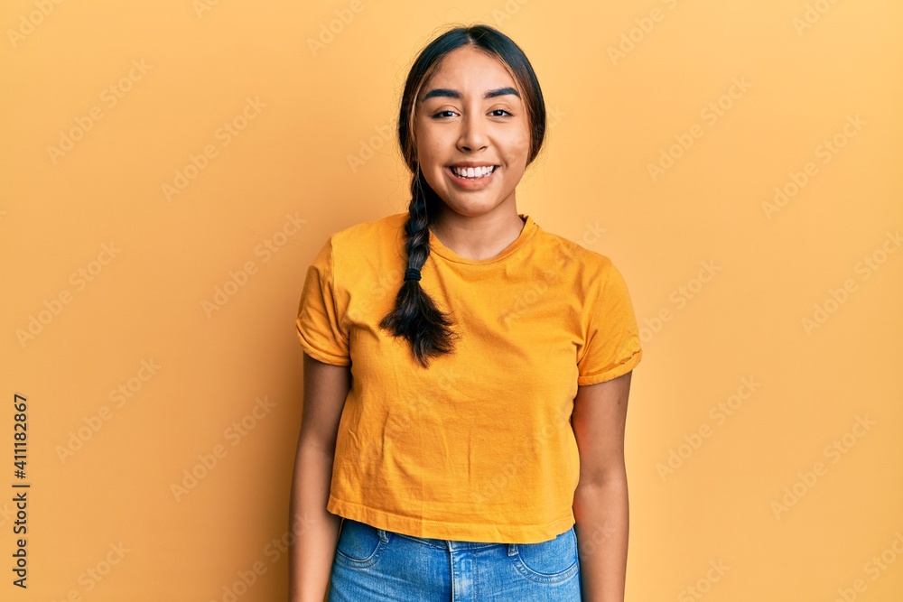 Young latin woman wearing casual clothes looking away to side with smile on face, natural expression. laughing confident.