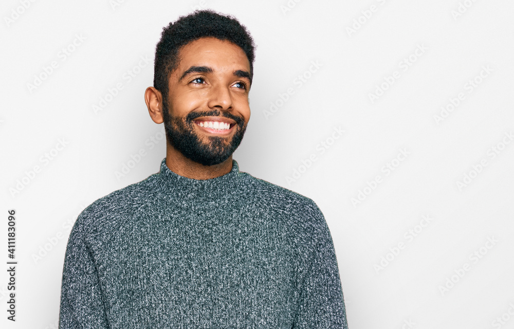 Young african american man wearing casual clothes looking away to side with smile on face, natural expression. laughing confident. Young african american man wearing casual clothes looking away to side with smile on face, natural expression. laughing confident.