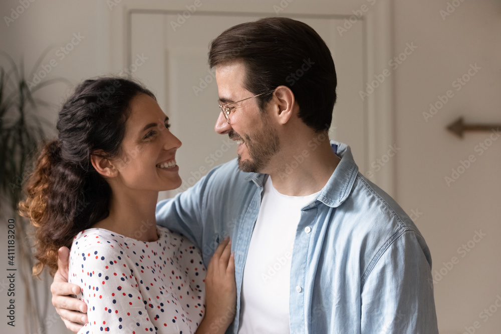Strong and happy marriage. Affectionate caring millennial husband and wife cuddling supporting trusting one another looking in eyes with love. Romantic young couple embracing enjoying date at home Strong and happy marriage. Affectionate caring millennial husband and wife cuddling supporting trusting one another looking in eyes with love. Romantic young couple embracing enjoying date at home