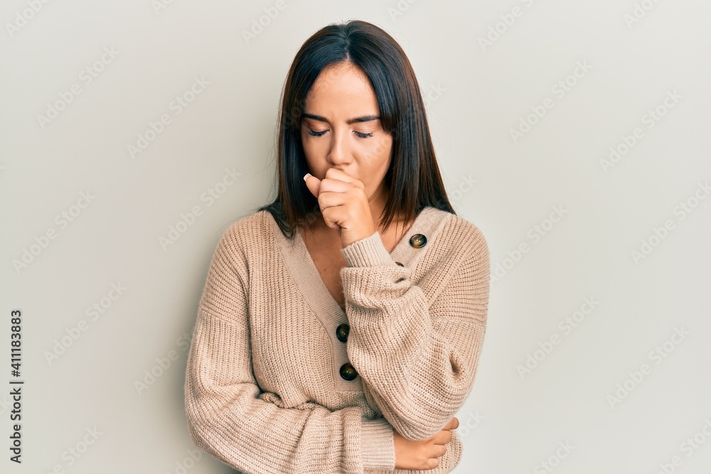 Young beautiful hispanic girl wearing casual winter sweater feeling unwell and coughing as symptom for cold or bronchitis. health care concept. Young beautiful hispanic girl wearing casual winter sweater feeling unwell and coughing as symptom for cold or bronchitis. health care concept.