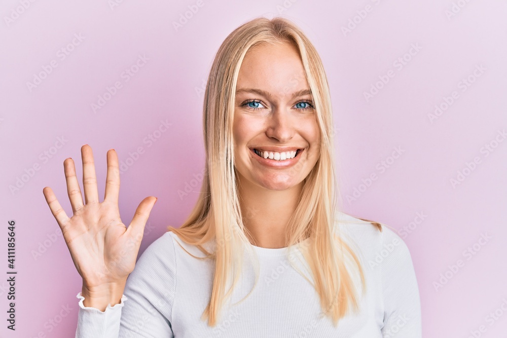 Young blonde girl wearing casual clothes showing and pointing up with fingers number five while smiling confident and happy. Young blonde girl wearing casual clothes showing and pointing up with fingers number five while smiling confident and happy.