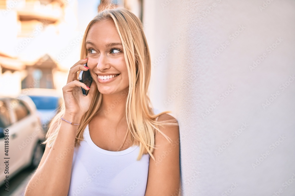 Young blonde girl smiling happy talking on the smartphone at the city. Young blonde girl smiling happy talking on the smartphone at the city.