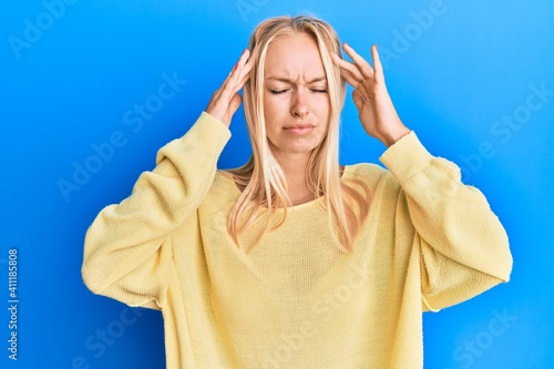 Young blonde girl wearing casual clothes with hand on head, headache because stress. suffering migraine.