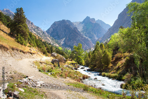 The natural landscape of mountains in Tajikistan on a sunny bright day. Amazing view on Fann mountains with mountain stream near hiking trail. photo