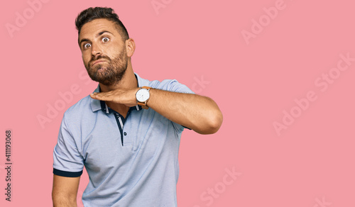 Handsome man with beard wearing casual clothes cutting throat with hand as knife, threaten aggression with furious violence