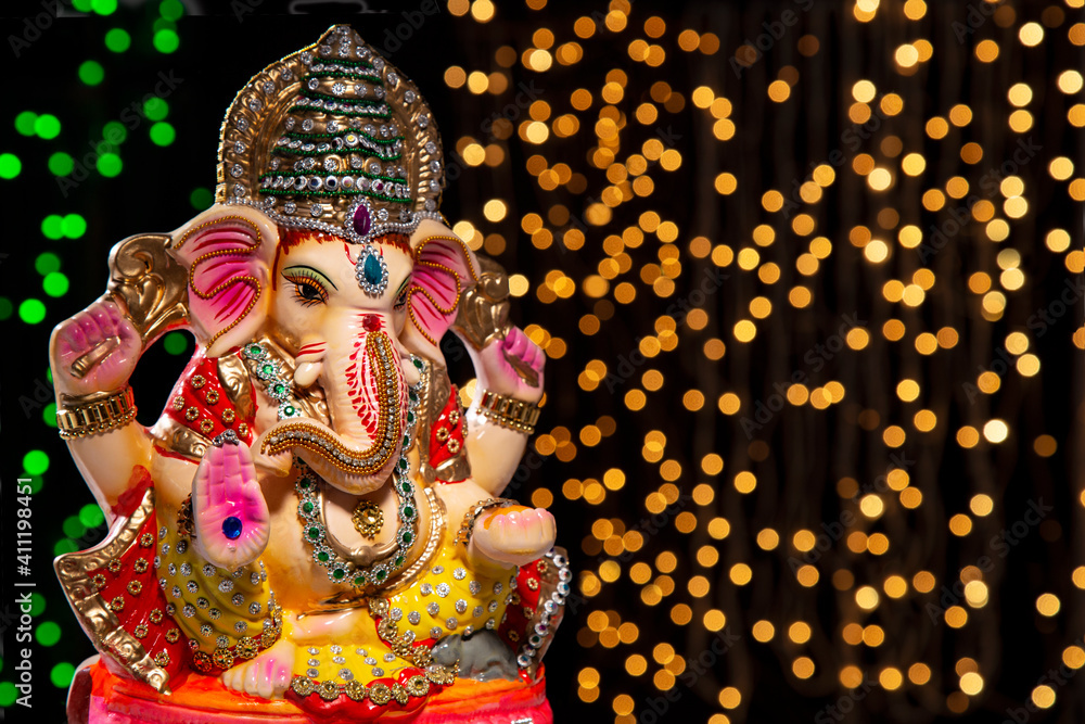 ganesh idol with lights in background	