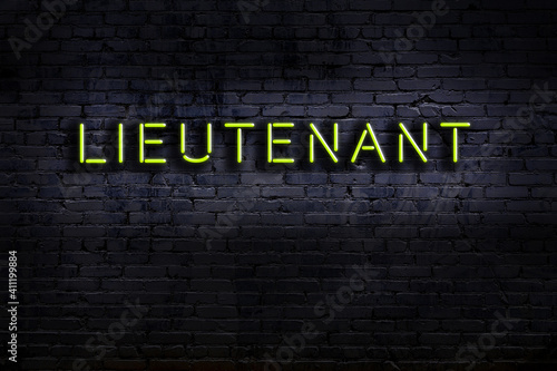 Night view of neon sign on brick wall with inscription lieutenant