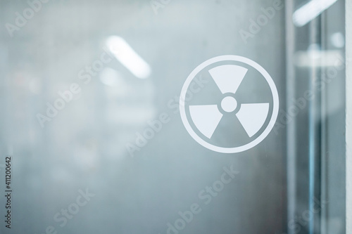 Radiation zone sign sticker on window of laboratory room. Health and safety concept