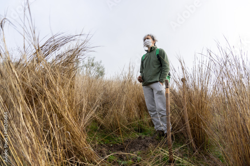 Stock photo of hard working woman wearing face mask using shovel in the countryside helping to reforest. © Manuel