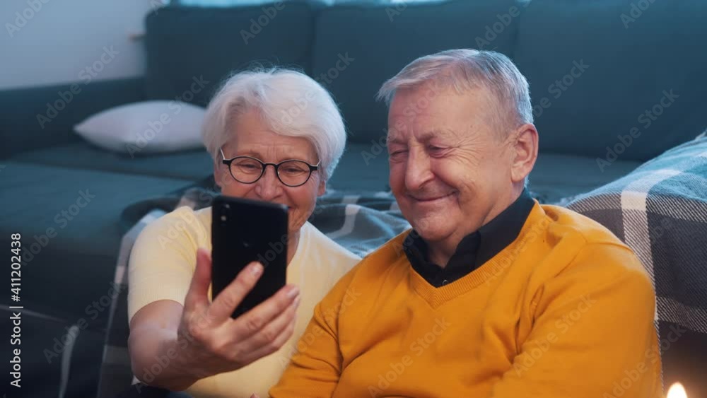 Happy retired couple taking selfie on the smartphone. High quality 4k footage Happy retired couple taking selfie on the smartphone. High quality 4k footage