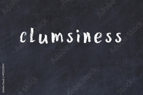 Foto College chalk desk with the word clumsiness written on in