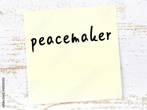 Foto Yellow sheet of paper with word peacemaker. Reminder concept