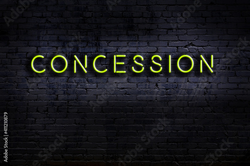 Fotografi Night view of neon sign on brick wall with inscription concession