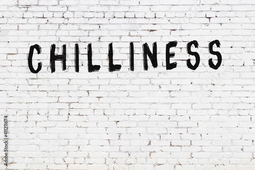 White wall with black paint inscription chilliness on it