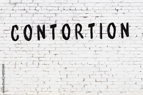Фотография White wall with black paint inscription contortion on it
