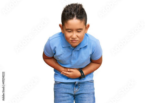 Little boy hispanic kid wearing casual clothes with hand on stomach because indigestion, painful illness feeling unwell. ache concept.
