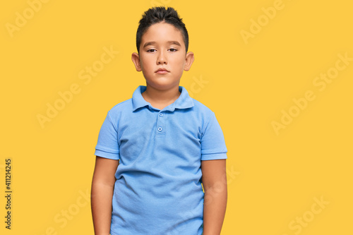 Little boy hispanic kid wearing casual clothes relaxed with serious expression on face. simple and natural looking at the camera.