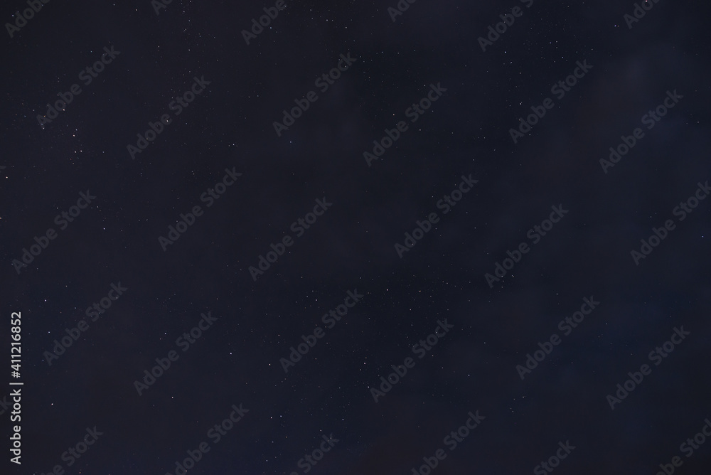 Stars in the night sky through the clouds on a summer night