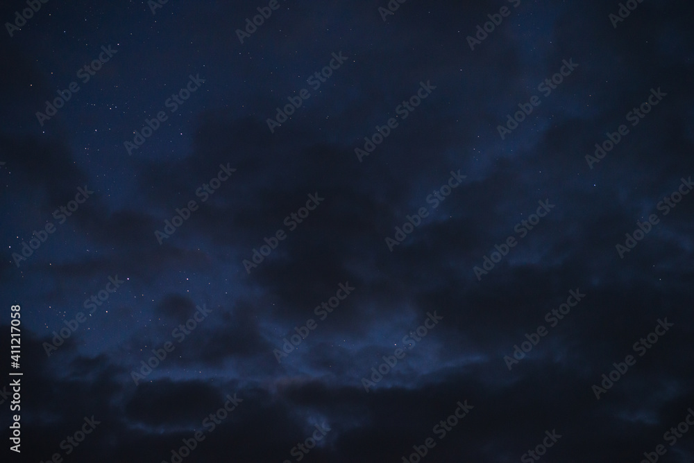 Stars in the night sky through the clouds on a summer night - obrazy, fototapety, plakaty 
