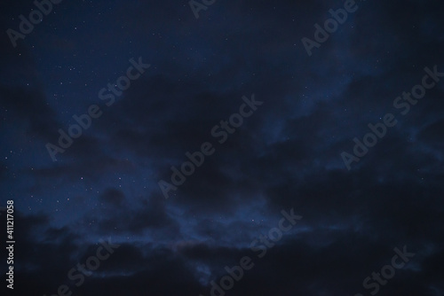 Stars in the night sky through the clouds on a summer night photo