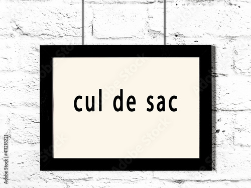 Black frame hanging on white brick wall with inscription cul de sac