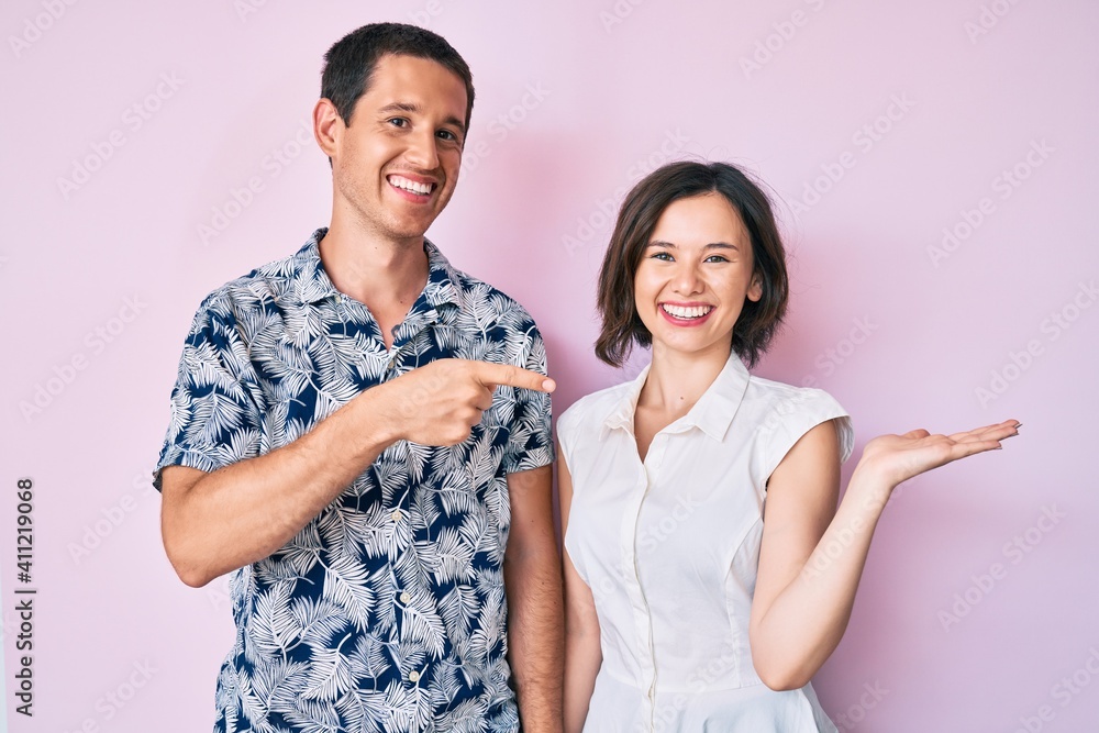 Beautiful couple wearing casual clothes amazed and smiling to the camera while presenting with hand and pointing with finger. Beautiful couple wearing casual clothes amazed and smiling to the camera while presenting with hand and pointing with finger.