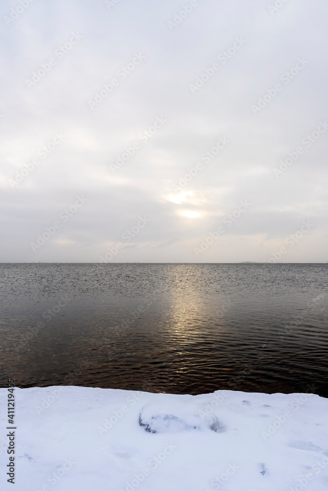 50 Shades of Grey in Helsinki, Finland. Winter is often grey in Helsinki, sun just peaks through the clouds and over the water while light snow falls. 50 Shades of Grey in Helsinki, Finland. Winter is often grey in Helsinki, sun just peaks through the clouds and over the water while light snow falls.