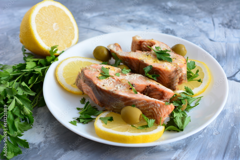roasted fish with lemon olives and parsley on the beige background roasted fish with lemon olives and parsley on the beige background