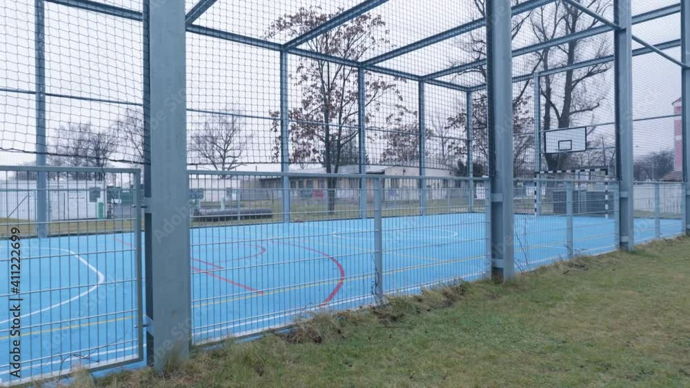 dolly shot of the basketball pitch with the steel poles. cloudy sky. Trees in the background. dolly shot of the basketball pitch with the steel poles. cloudy sky. Trees in the background.