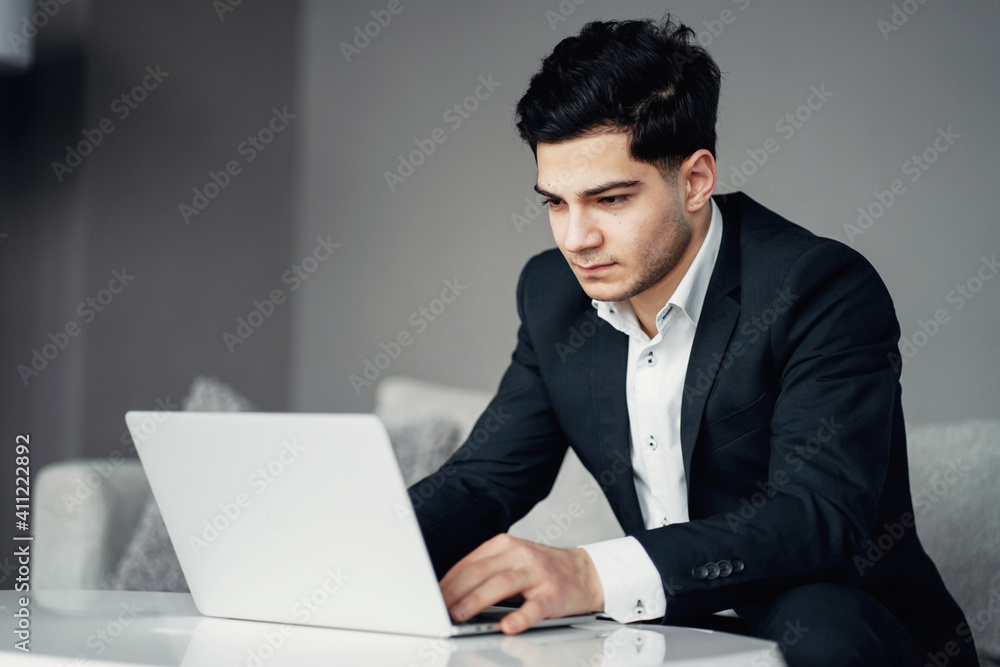 a professional lawyer works on a laptop, sits in a chair and types a message to a project partner. employee Chief Credit Processing Manager. stylish modern office in the city center. by a professional lawyer works on a laptop, sits in a chair and types a message to a project partner. employee Chief Credit Processing Manager. stylish modern office in the city center. by