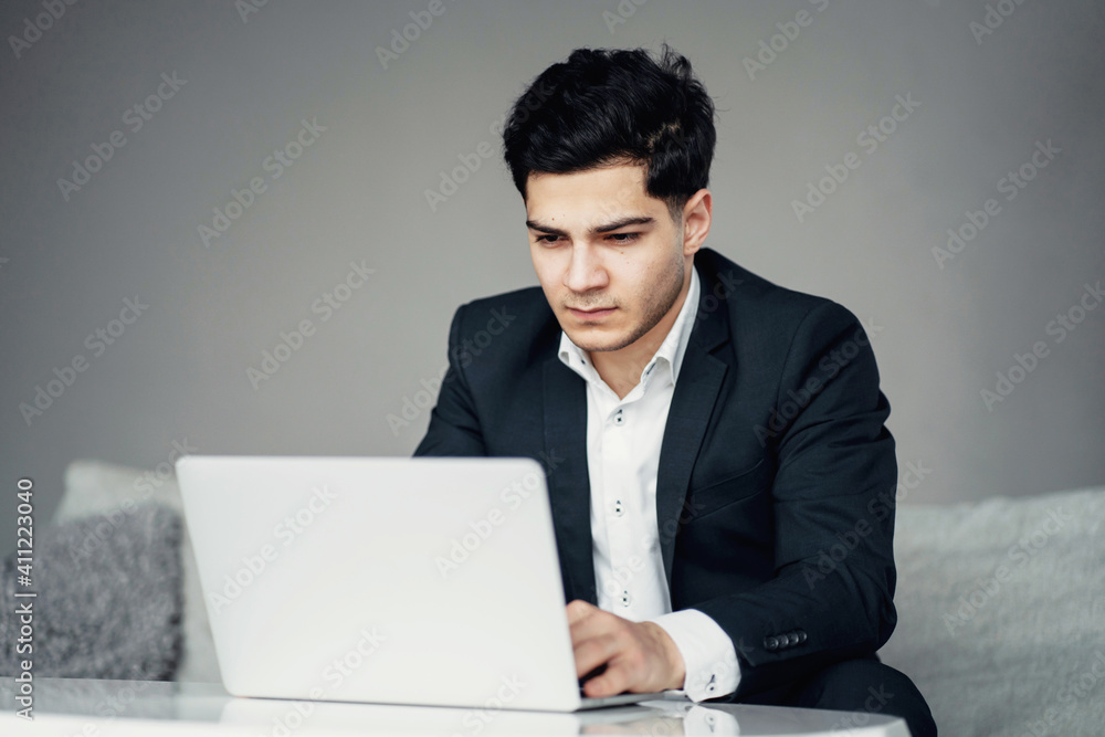 a professional male lawyer works on a laptop computer. Sitting on the couch. a manager in a company for finance in a bank. prints the text message to the partner. a professional male lawyer works on a laptop computer. Sitting on the couch. a manager in a company for finance in a bank. prints the text message to the partner.