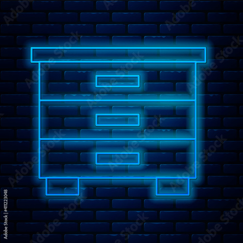 Glowing neon line Furniture nightstand icon isolated on brick wall background. Vector.