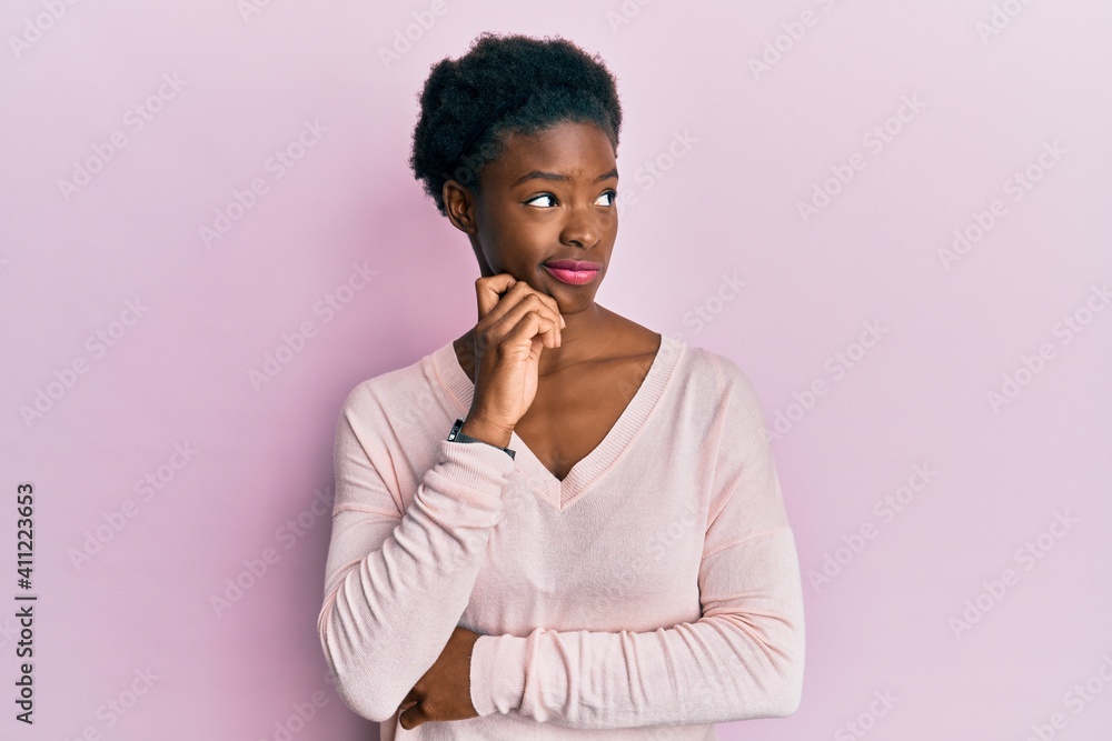 Young african american girl wearing casual clothes thinking concentrated about doubt with finger on chin and looking up wondering Young african american girl wearing casual clothes thinking concentrated about doubt with finger on chin and looking up wondering