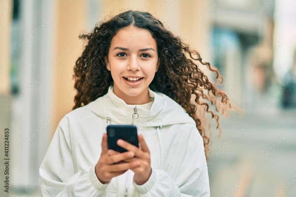 Beautiful hispanic girl smiling happy using smartphone at the city. Beautiful hispanic girl smiling happy using smartphone at the city.