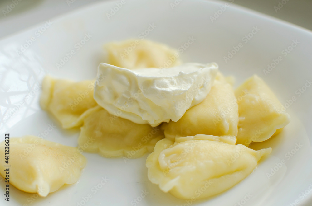 Dumplings with pepper, sour cream in a beautiful plate Dumplings with pepper, sour cream in a beautiful plate
