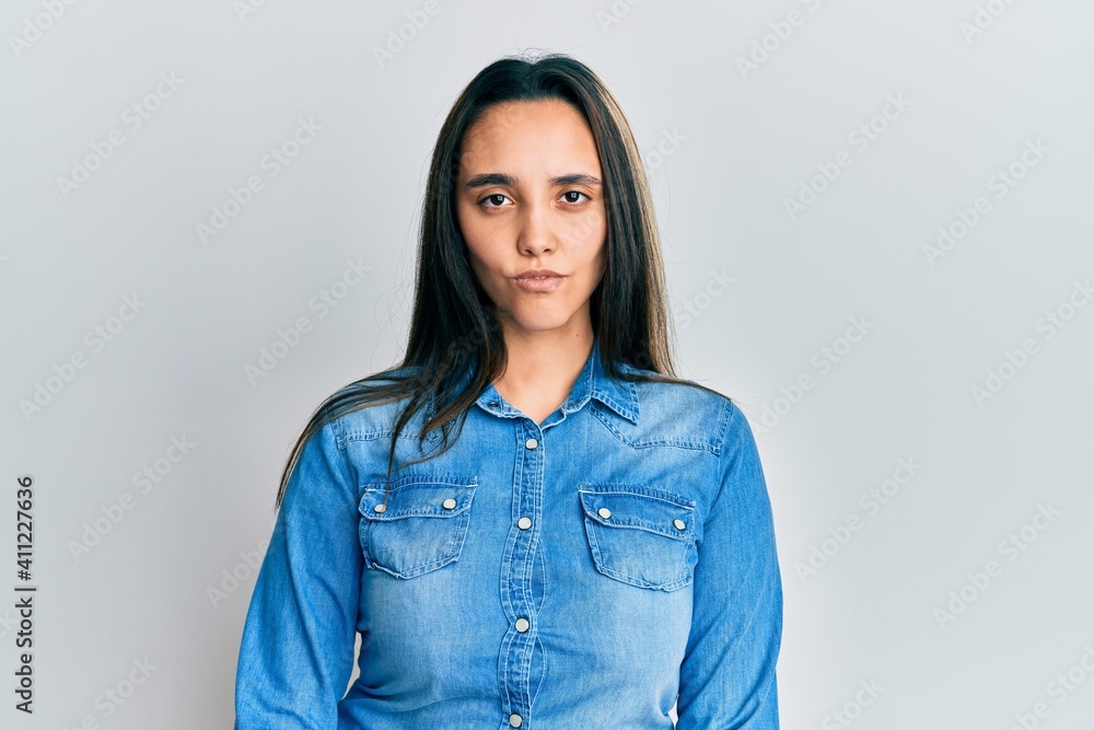 Young hispanic woman wearing casual denim jacket skeptic and nervous, frowning upset because of problem. negative person. Young hispanic woman wearing casual denim jacket skeptic and nervous, frowning upset because of problem. negative person.