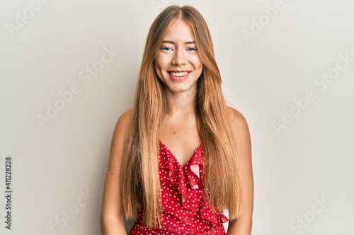 Beautiful young blonde woman wearing summer dress with a happy and cool smile on face. lucky person.