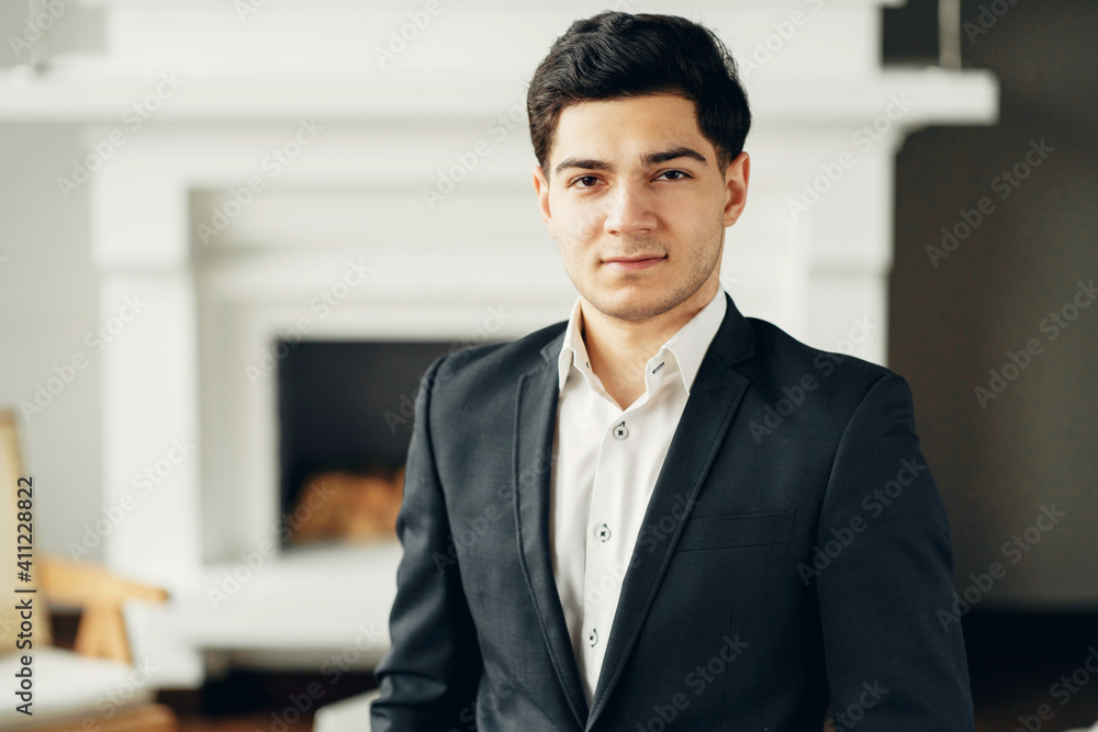 portrait of a bank manager looking at the camera smiling. a man in a business suit is in a modern office. chief administrator portrait of a bank manager looking at the camera smiling. a man in a business suit is in a modern office. chief administrator