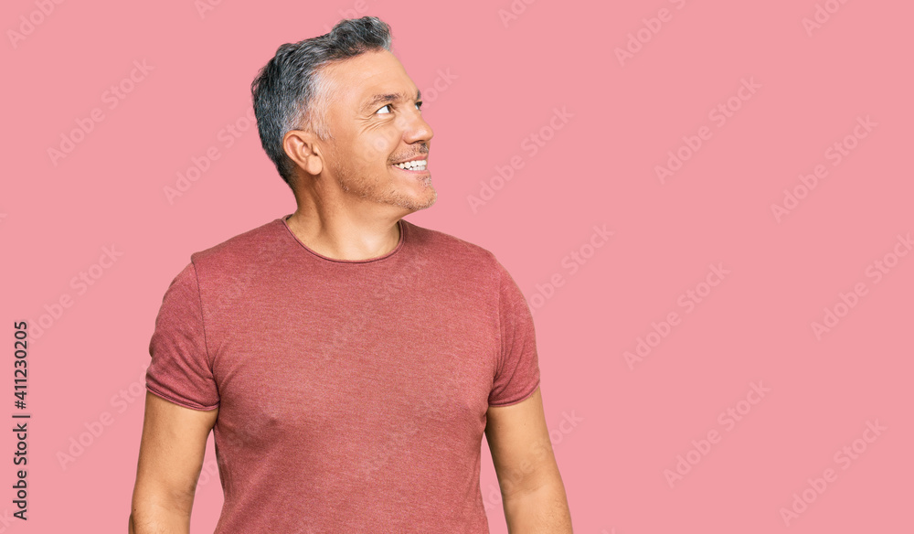 Handsome middle age man wearing casual clothes looking away to side with smile on face, natural expression. laughing confident. Handsome middle age man wearing casual clothes looking away to side with smile on face, natural expression. laughing confident.