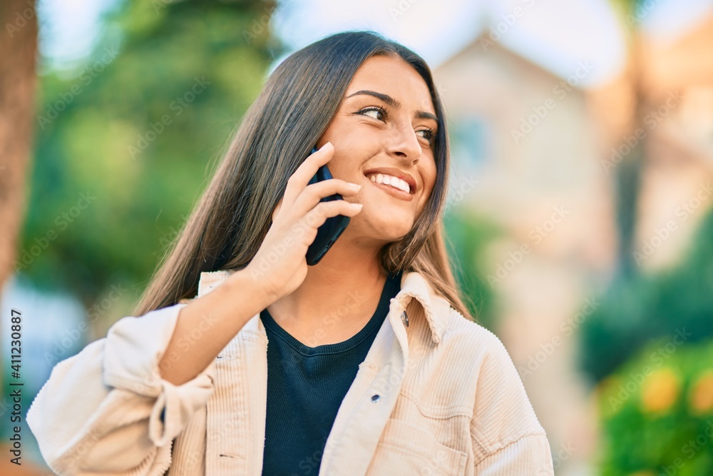 Young hispanic girl smiling happy talking on the smartphone at the park. Young hispanic girl smiling happy talking on the smartphone at the park.