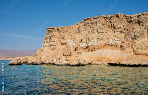 beautiful seascape with clear turquoise and blue water and bright yellow rocks off the coast of Sharm El Sheikh in egypt 