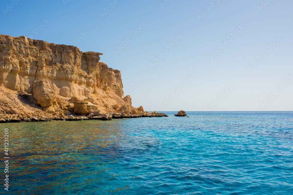 Fototapeta premium beautiful seascape with clear turquoise and blue water and bright yellow rocks off the coast of Sharm El Sheikh in egypt 