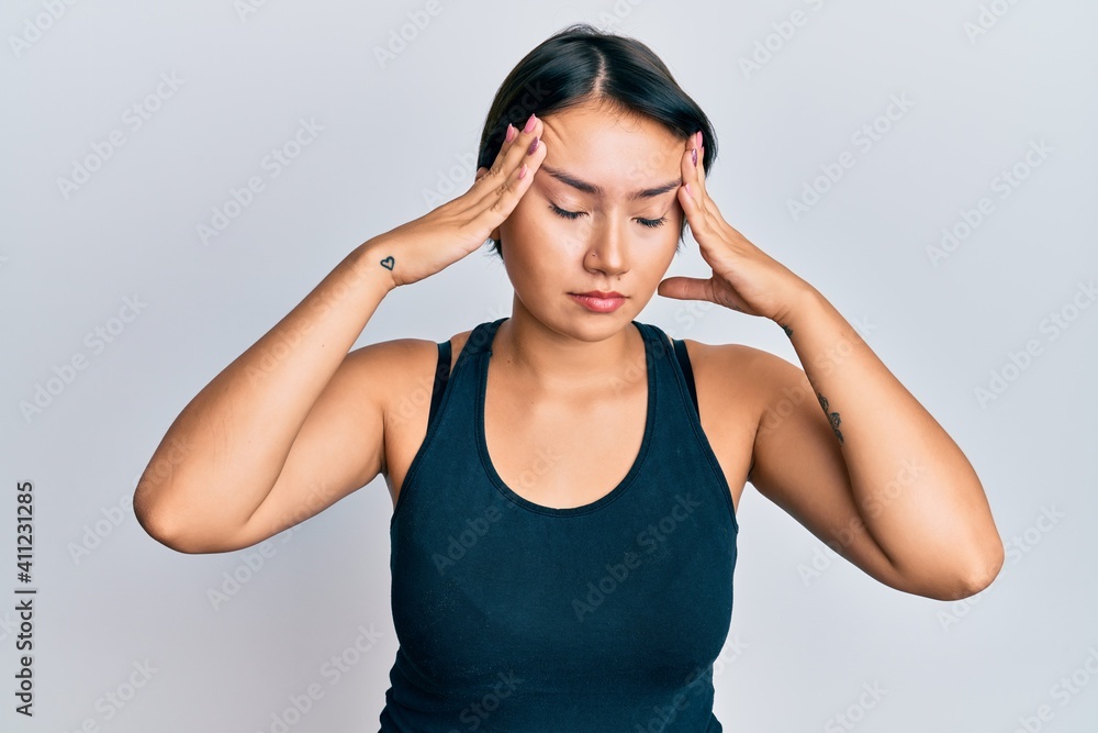 Beautiful young woman with short hair wearing casual clothes with hand on head, headache because stress. suffering migraine. Beautiful young woman with short hair wearing casual clothes with hand on head, headache because stress. suffering migraine.