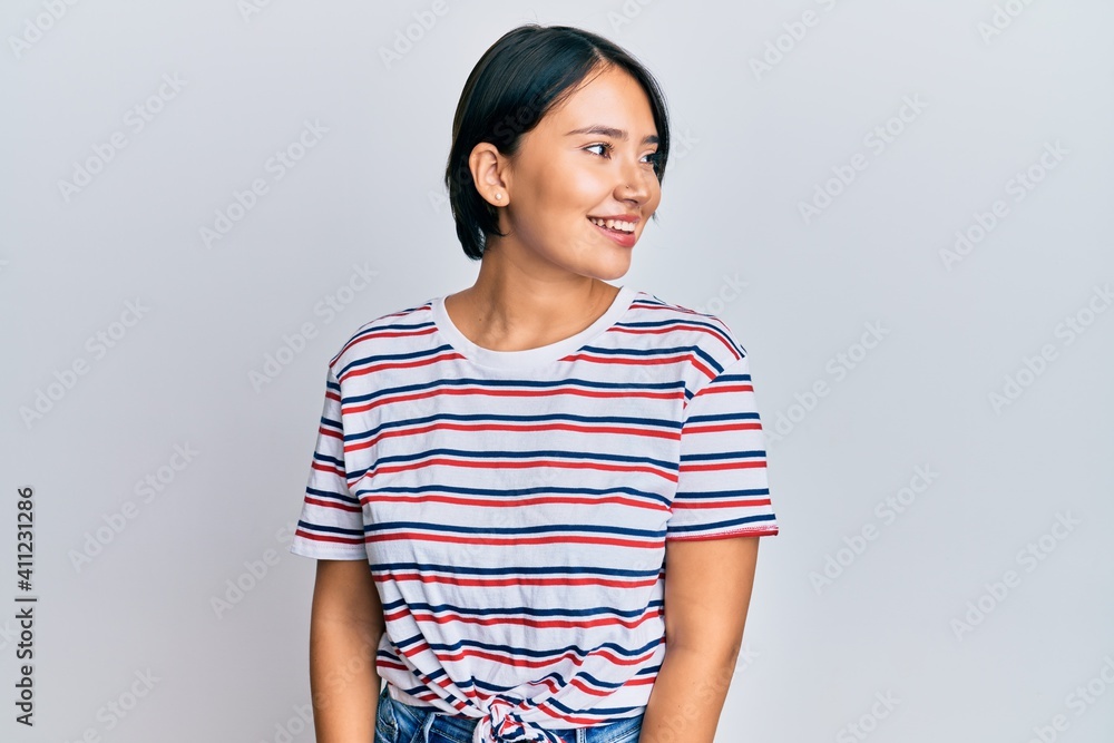 Beautiful young woman with short hair wearing casual clothes looking away to side with smile on face, natural expression. laughing confident. Beautiful young woman with short hair wearing casual clothes looking away to side with smile on face, natural expression. laughing confident.